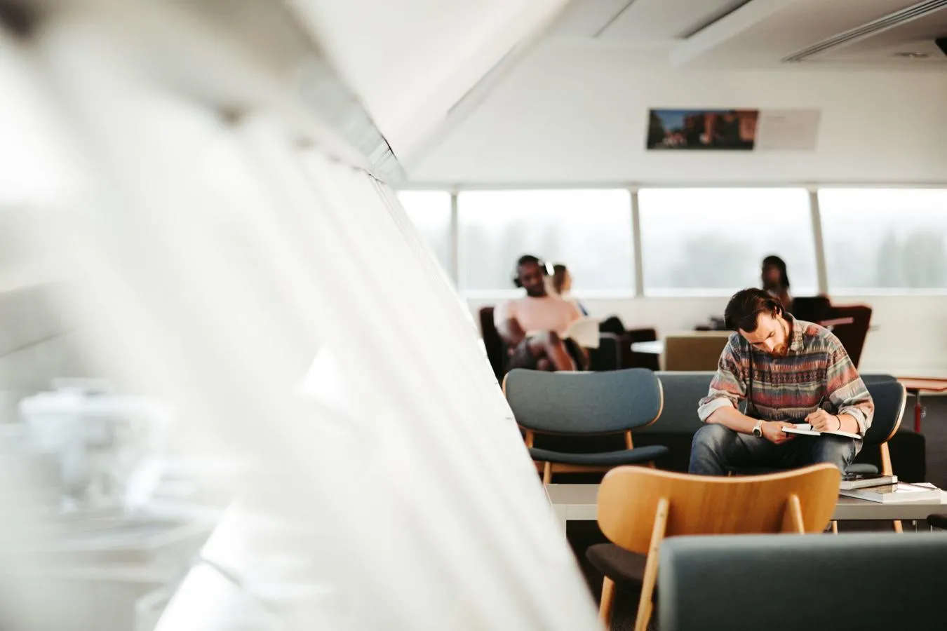 Student studying at the top level of the Library next to the window